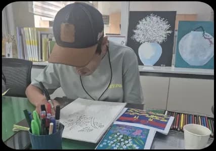 책상에서 그림 작업을 하는 활동 장면